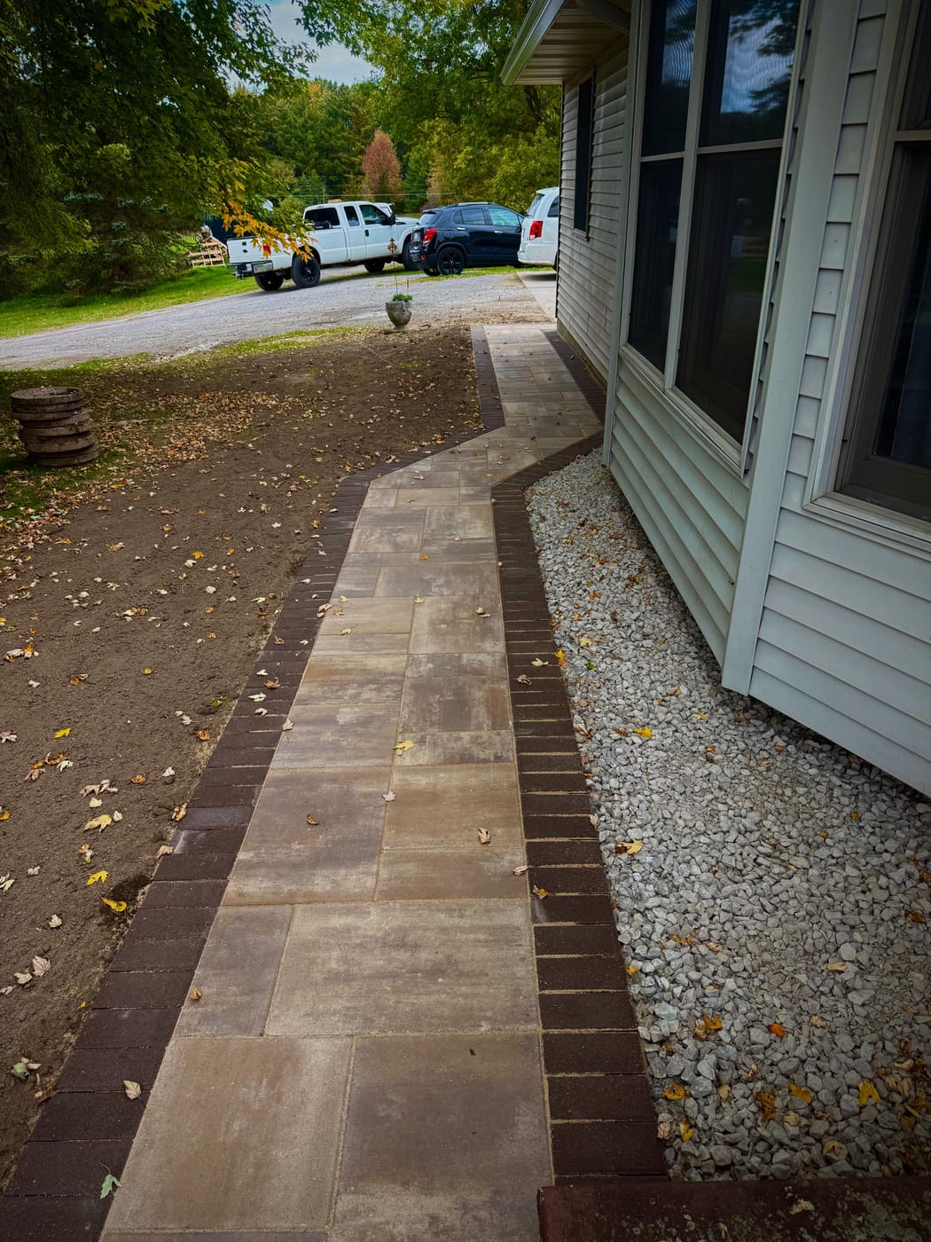 Winding paver walkway with a gravel drip edge along the foundation